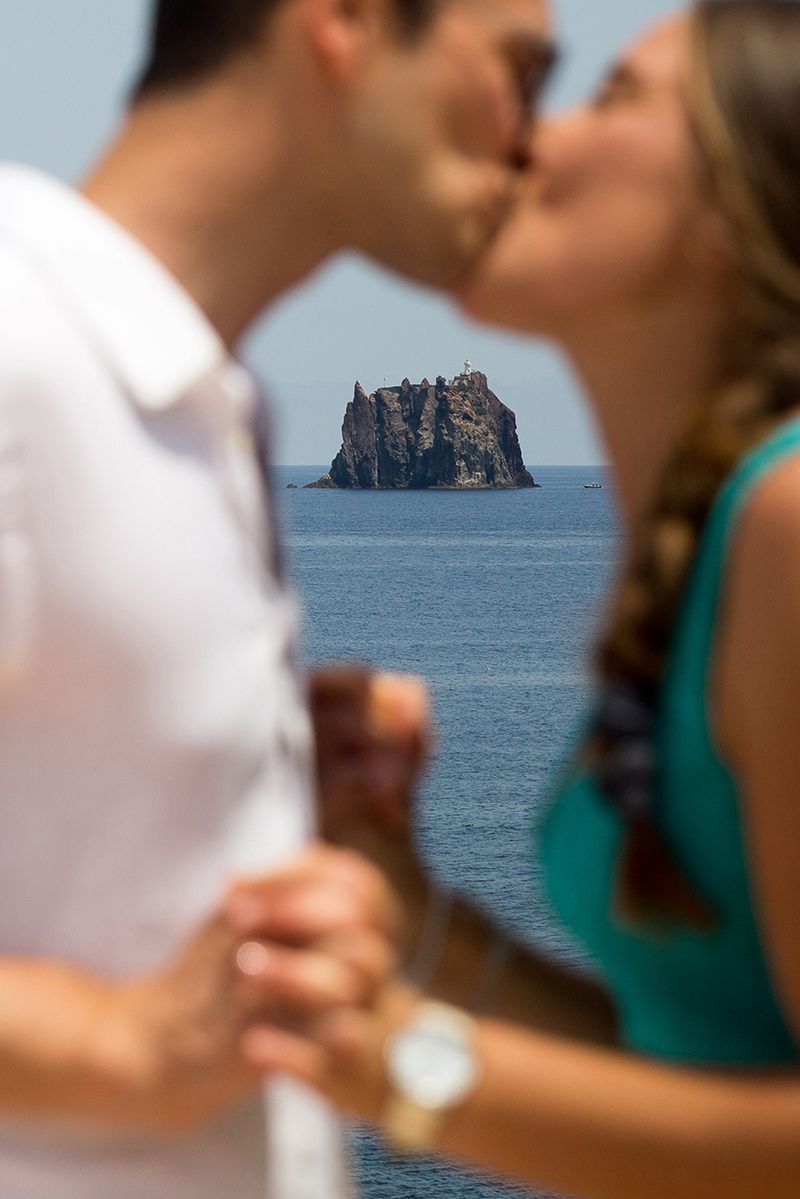 Matrimonio a Stromboli: futuri sposi con bacio strombolicchio sullo sfondo